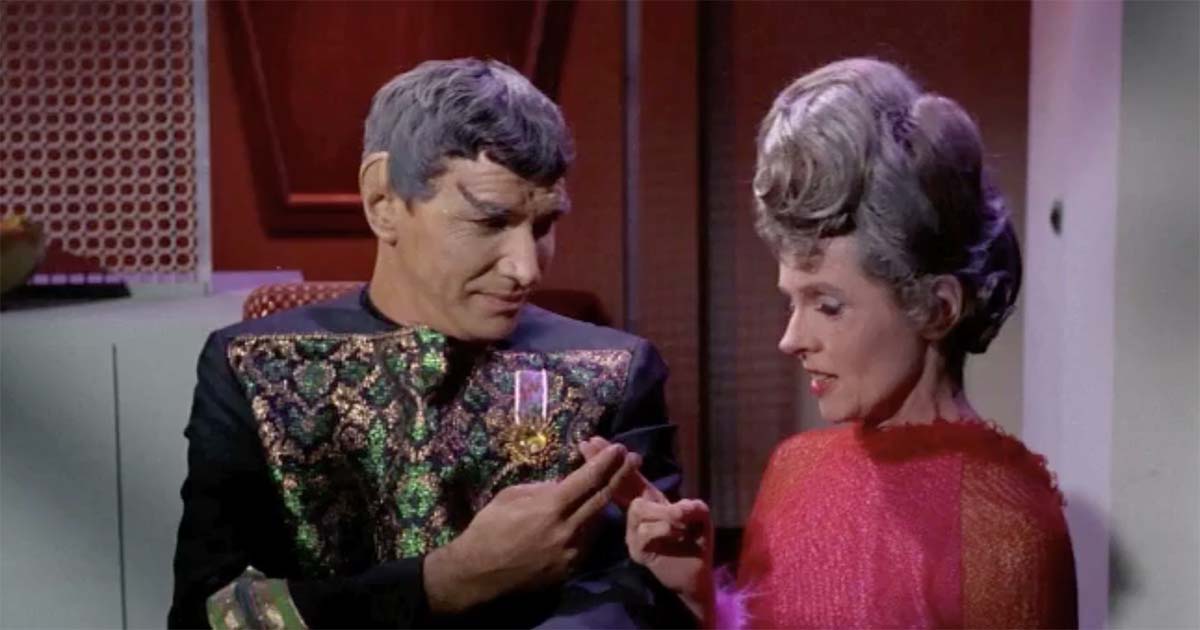 Spock standing between his parents, Sarek and Amanda Grayson, aboard a starship interior, reflecting the union of Vulcan logic and human emotion in Star Trek.
