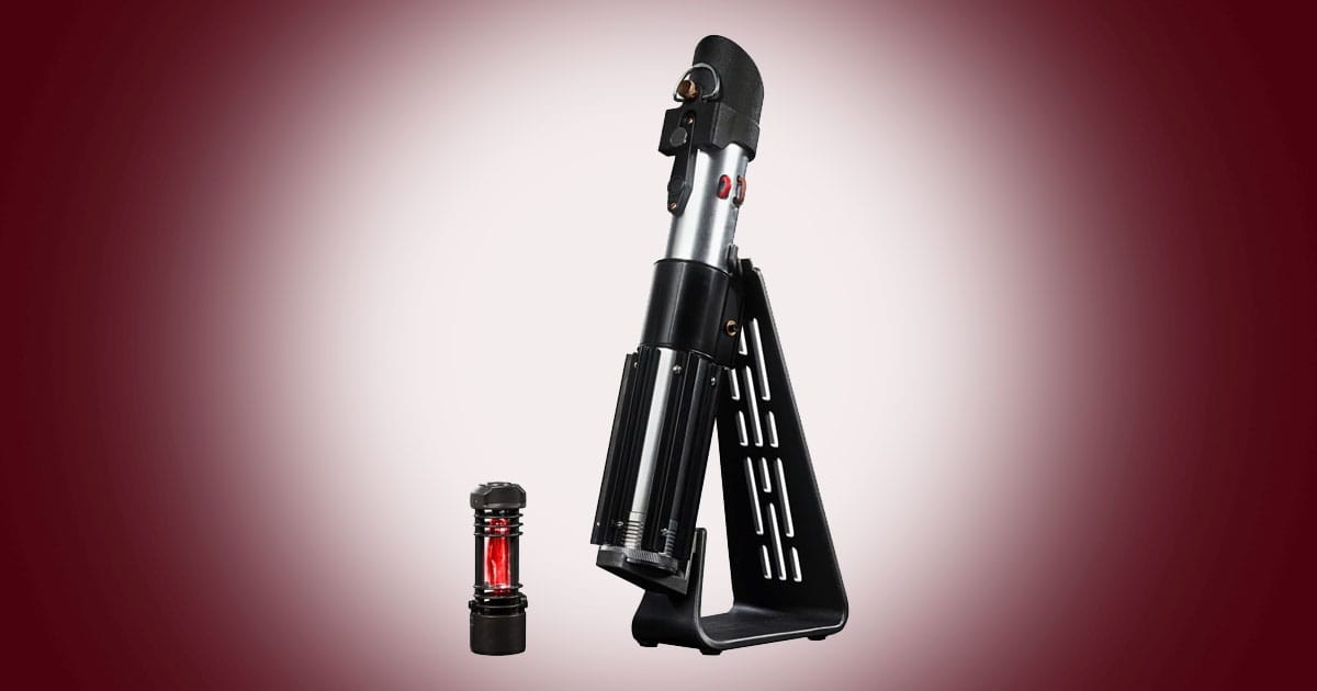 Darth Vader Force FX Elite lightsaber hilt with removable red kyber crystal displayed on black stand.