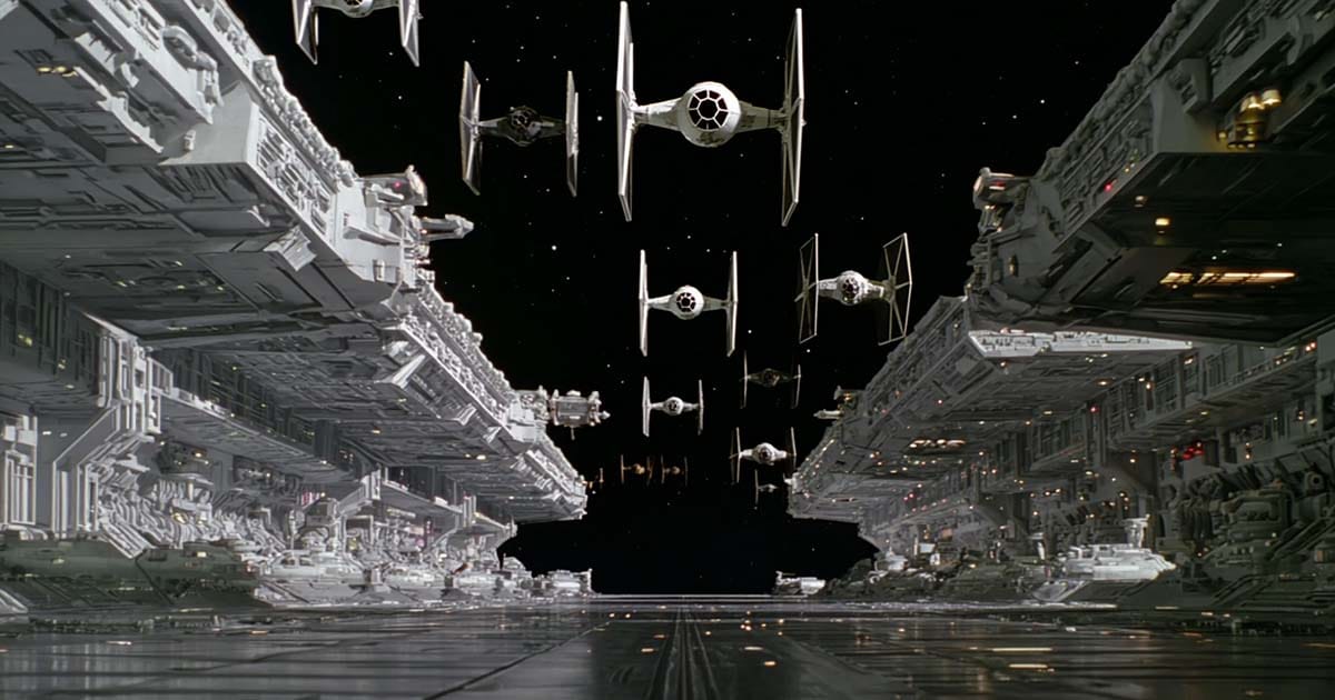 Imperial TIE Fighters launching in formation between two massive Star Destroyers in deep space.