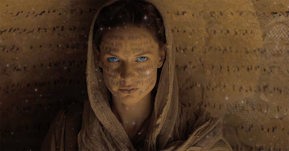 Close-up of Lady Jessica with blue spice-altered eyes and projected script across her face.