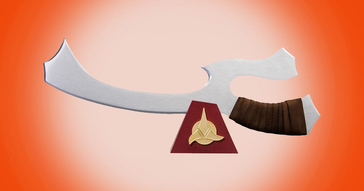 Star Trek Klingon mek'leth prop replica with curved blade and leather grip displayed on stand with Klingon insignia.