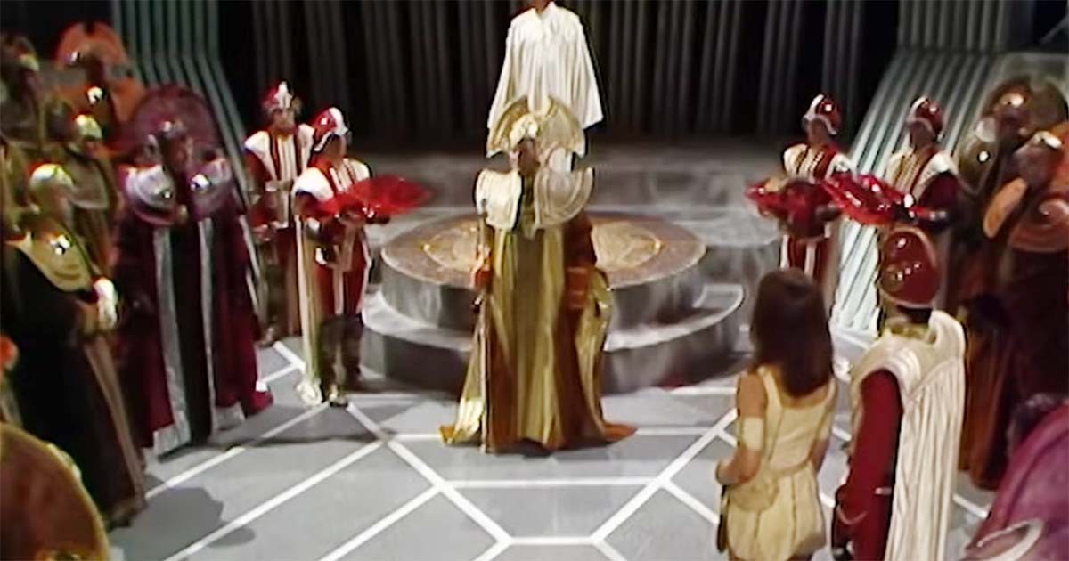 Time Lords gathered in ceremonial chamber on Gallifrey around central platform in Doctor Who.