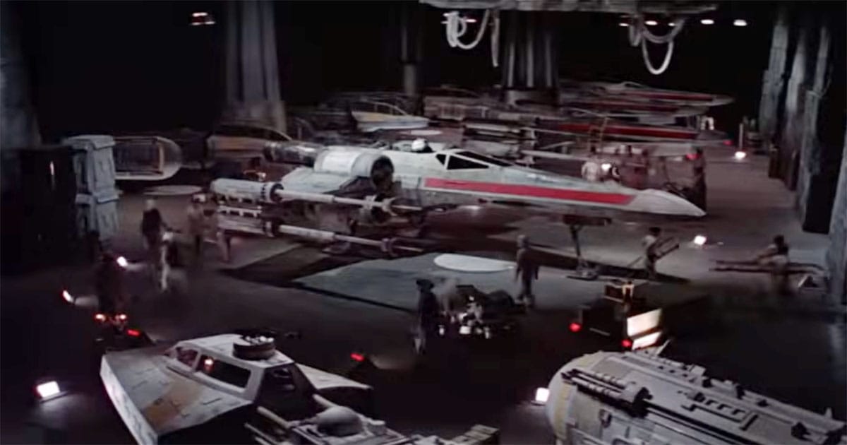 Rebel base hangar with X wing surrounded by technicians and equipment showing maintenance and preparation before flight in Star Wars