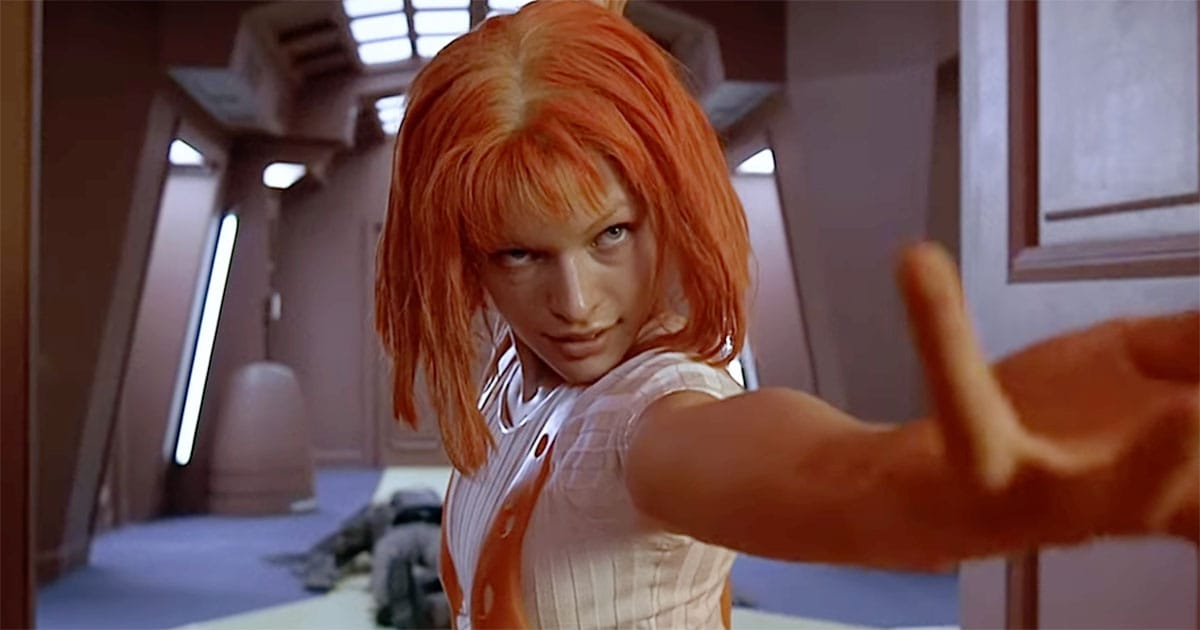 Leeloo extending her arm in stylized action pose inside futuristic corridor in The Fifth Element.