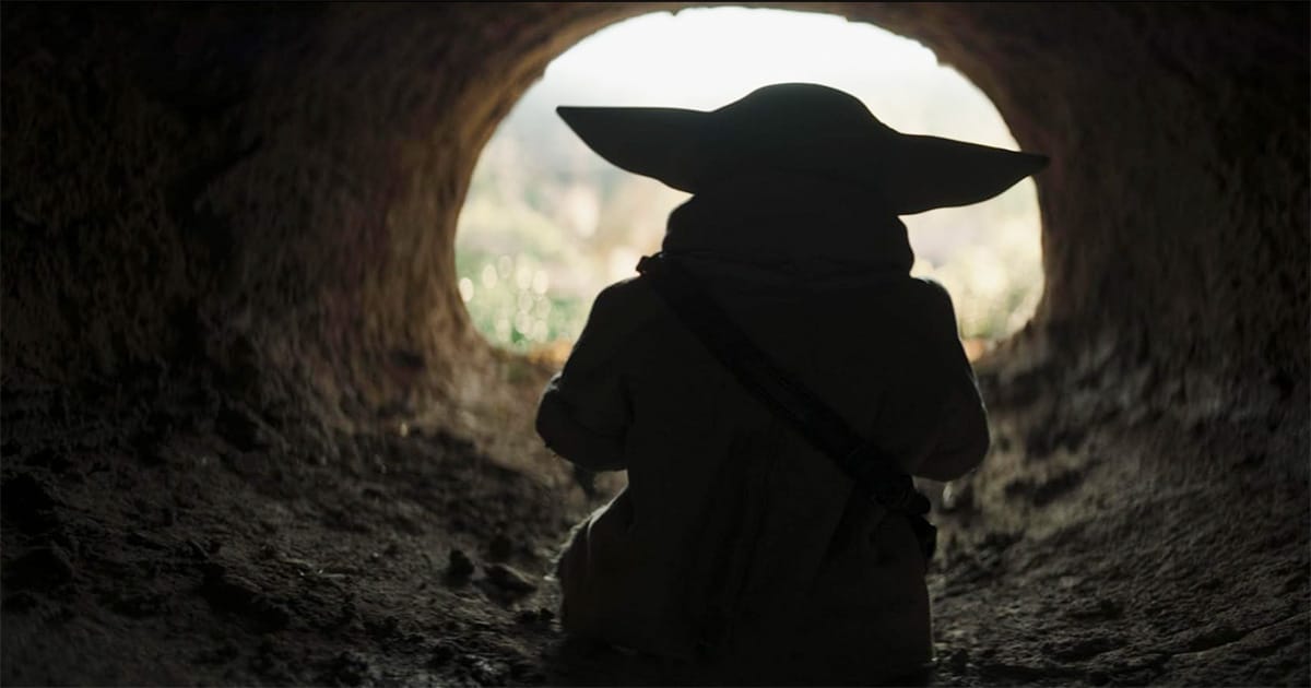 Grogu walking out of a tunnel.