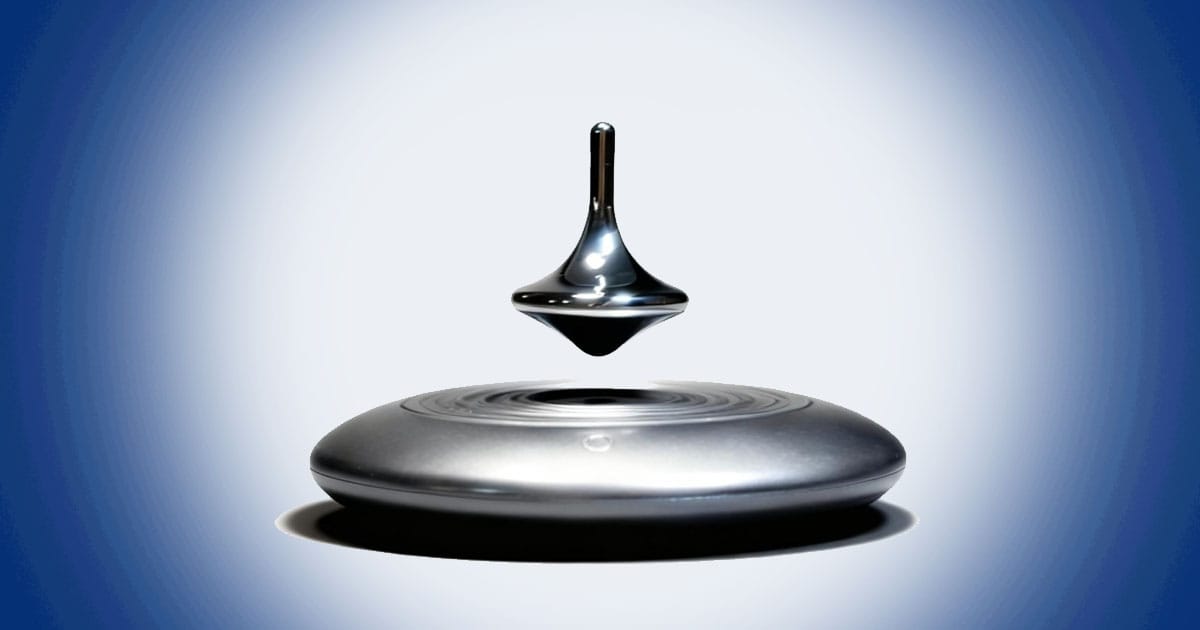 Magnetic levitating spinning top floating above metallic base with futuristic space age design inspired by classic science fiction technology.