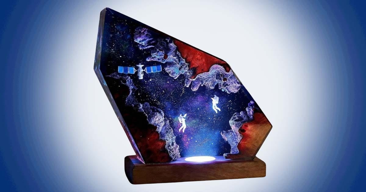 Handmade astronaut epoxy resin LED lamp with floating astronauts, glowing galaxy background, and deep space science fiction design.