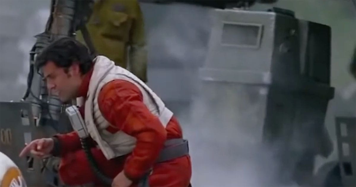 Gonk Droid beside Poe Dameron in a smoky "Star Wars" hangar bay.