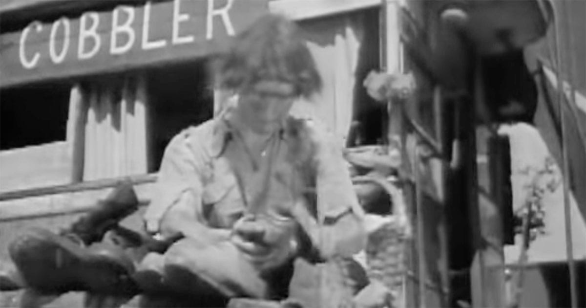 Man working as a cobbler in a ruined society in "Things to Come" (1936), showing the collapse into primitive conditions.