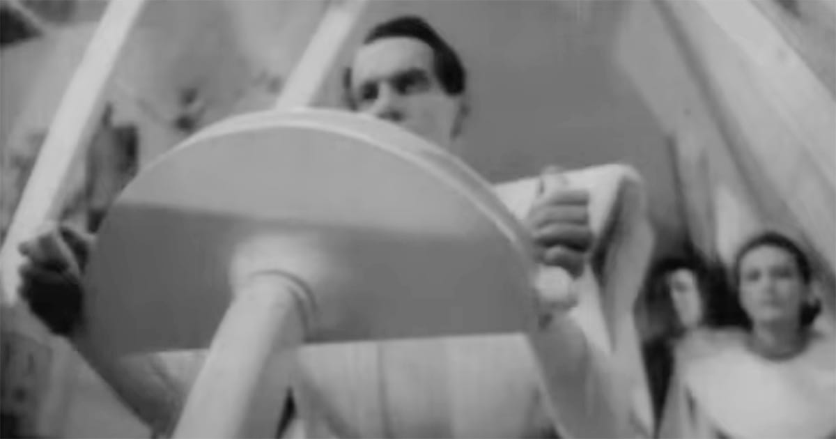 Man operating a futuristic control device in "Things to Come" (1936), symbolizing scientific authority and technological control.