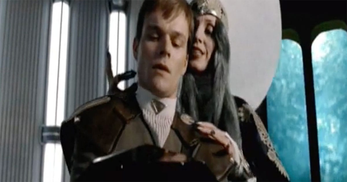 Reverend Mother standing behind Paul Atreides during Gom Jabbar test in "Dune"