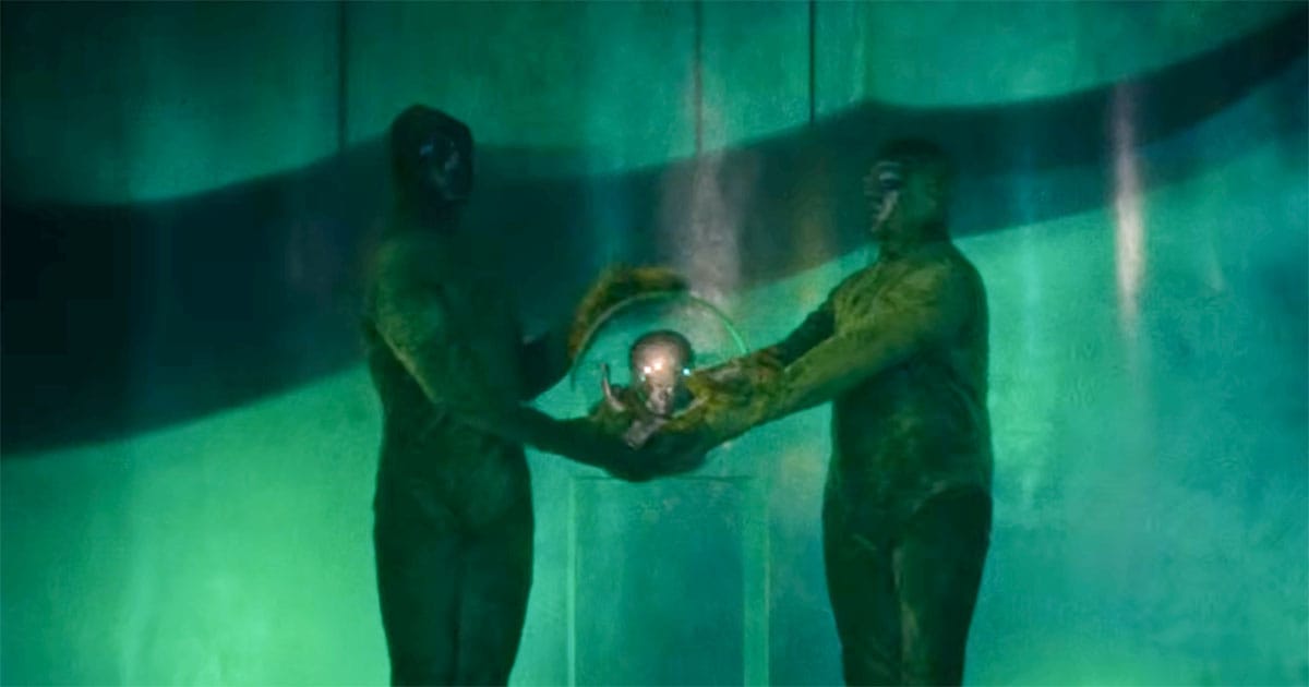 Scene from "Invaders from Mars" showing two alien figures holding a glowing brain inside a base, representing an organized force challenging human authority.