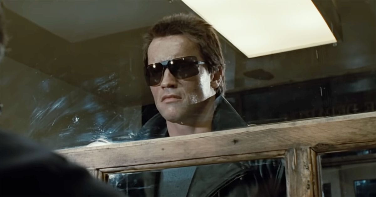 Arnold Schwarzenegger as the Terminator standing behind a glass partition in "The Terminator."