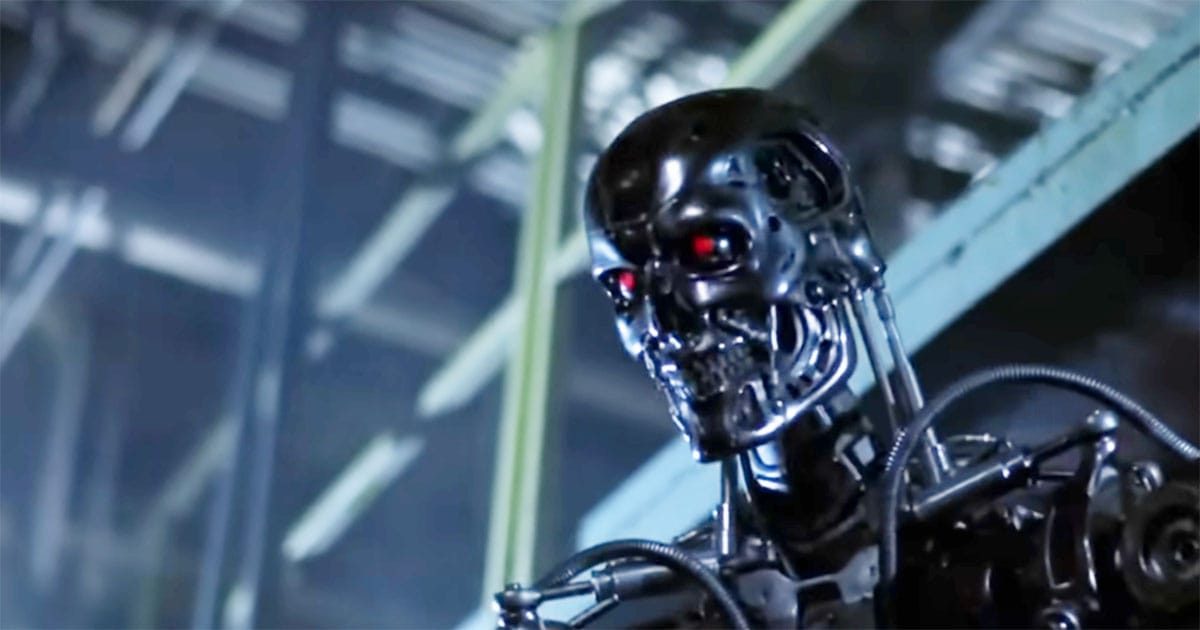 The Terminator endoskeleton with glowing red eyes inside an industrial factory setting in "The Terminator."