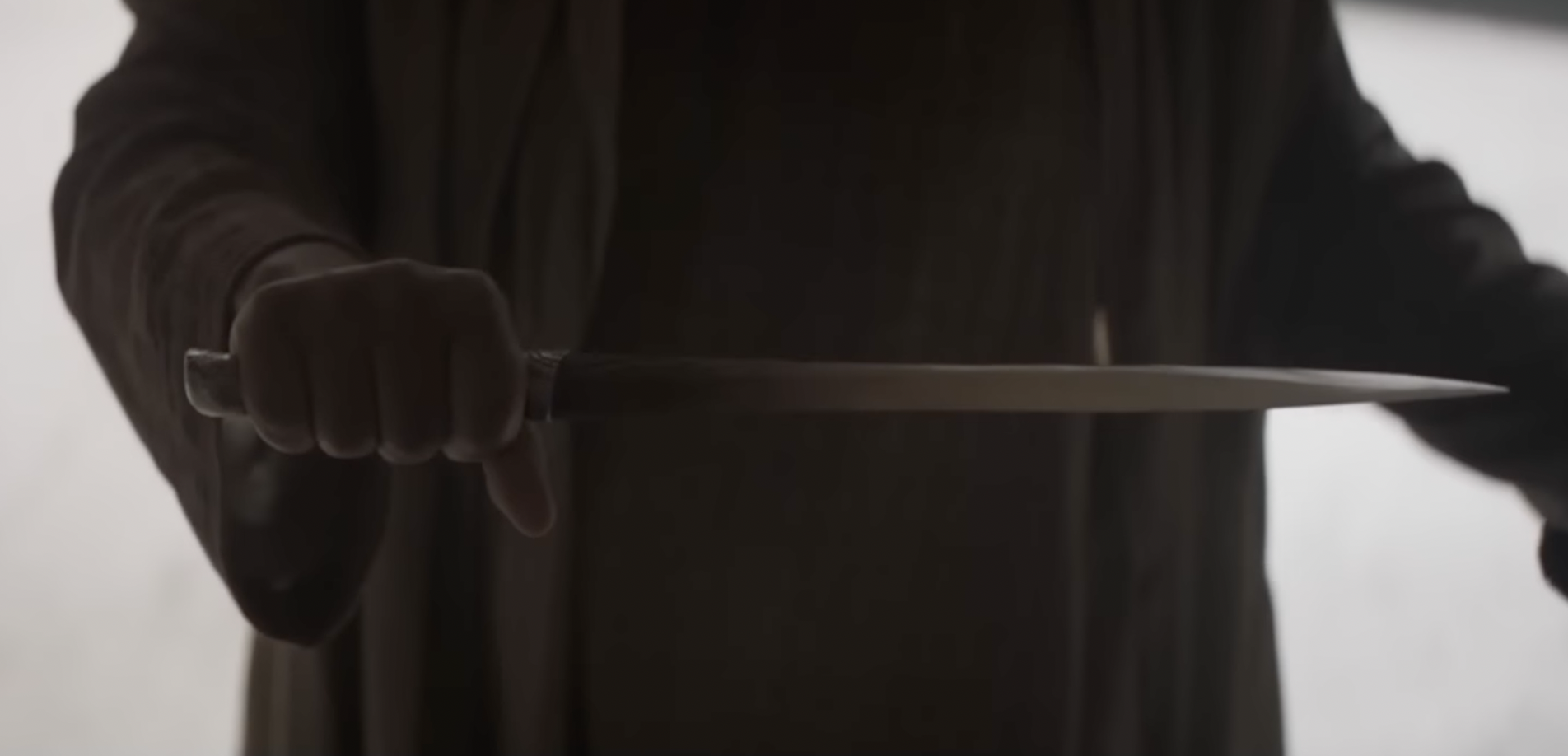 Close view of a Fremen crysknife held in shadowed light in "Dune."