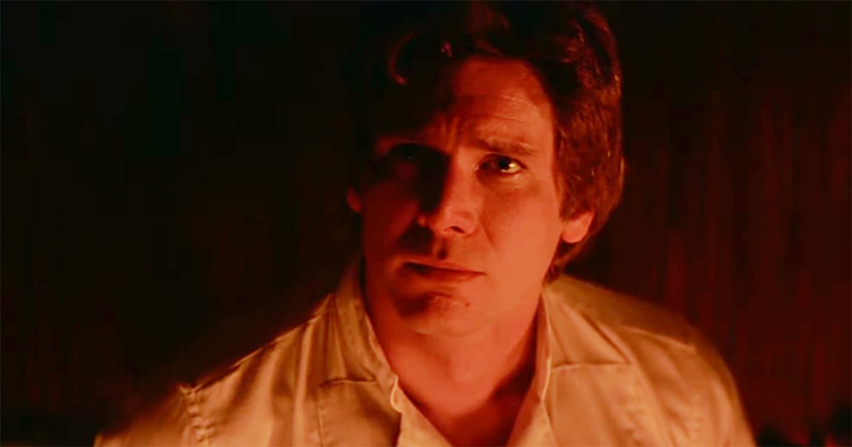 Han Solo sits in warm red lighting during a scene from "Star Wars: Return of the Jedi."