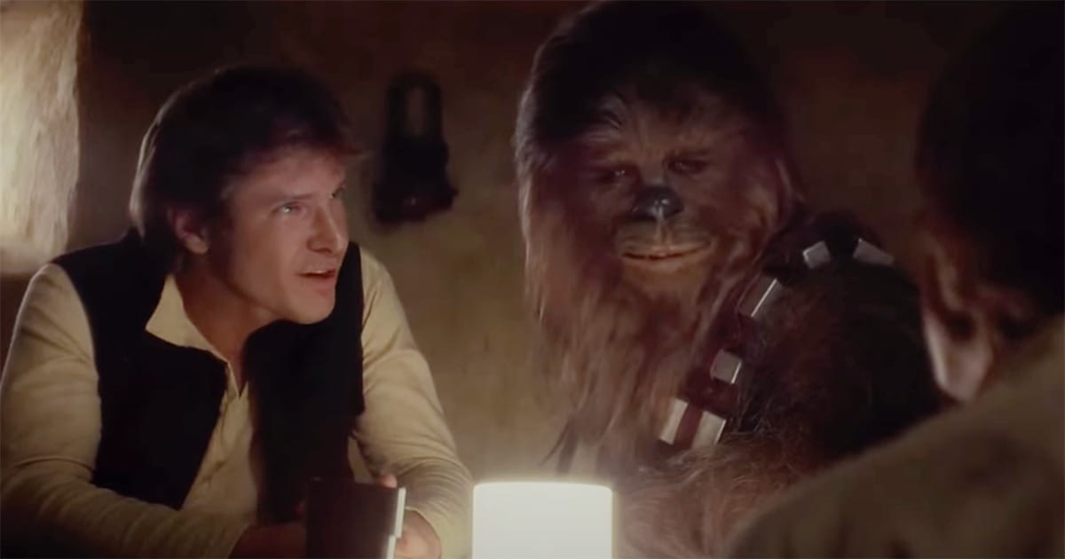 Han Solo and Chewbacca sit together at a table in a scene from "Star Wars: A New Hope."