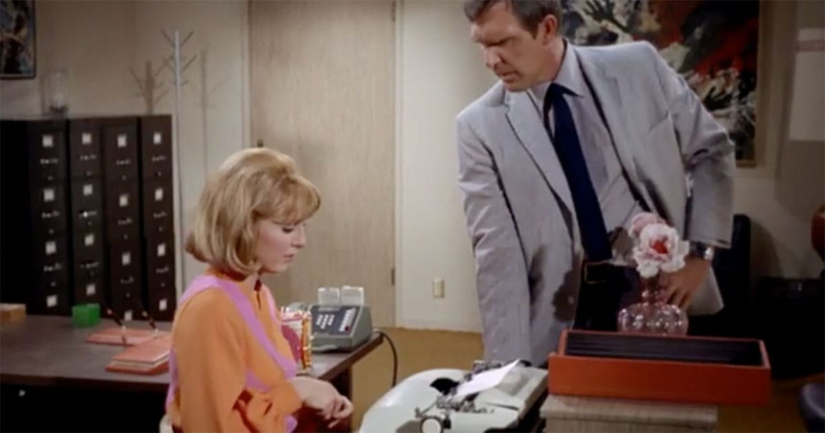 Roberta Lincoln sits at an office desk beside Gary Seven in the "Star Trek" episode "Assignment: Earth."