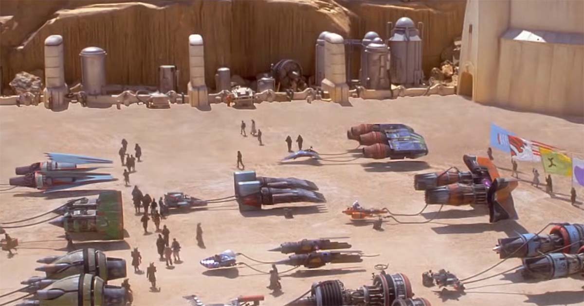 Multiple podracers are parked in a large desert staging area on Tatooine before a race, illustrating the space and infrastructure needed for podracing.