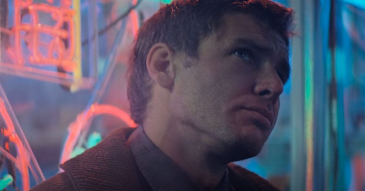 Rick Deckard stands beneath neon lights in futuristic Los Angeles in "Blade Runner."