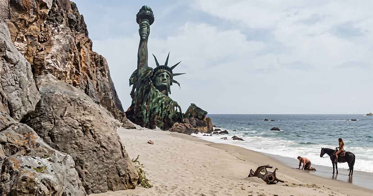 The ruined Statue of Liberty towers over Taylor on the beach in "Planet of the Apes" (1968).