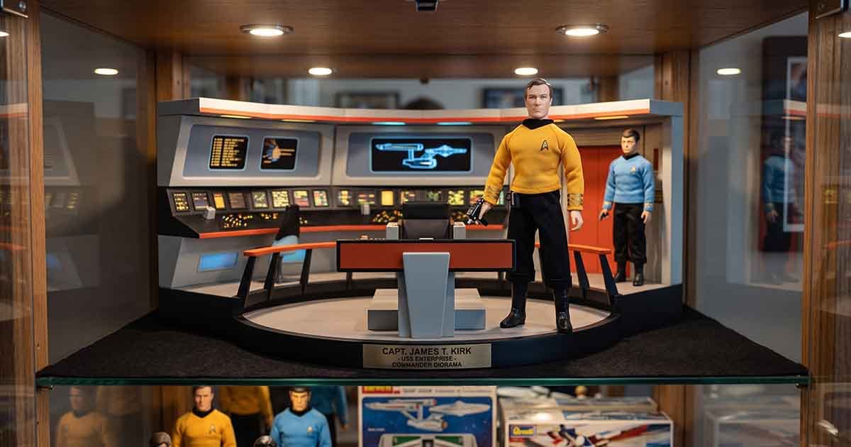 Captain Kirk action figure posed on a detailed USS Enterprise bridge diorama with a Spock action figure in the background