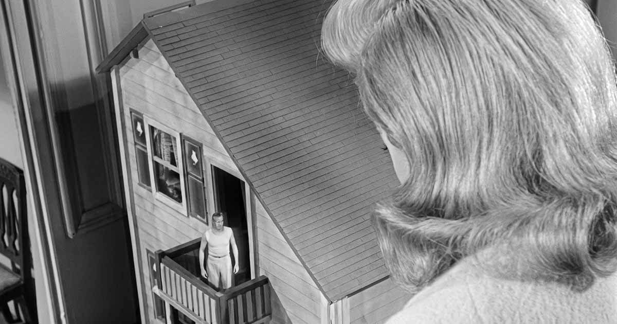 Louise Carey looks down at the shrinking Scott standing on the balcony of his dollhouse in “The Incredible Shrinking Man.”