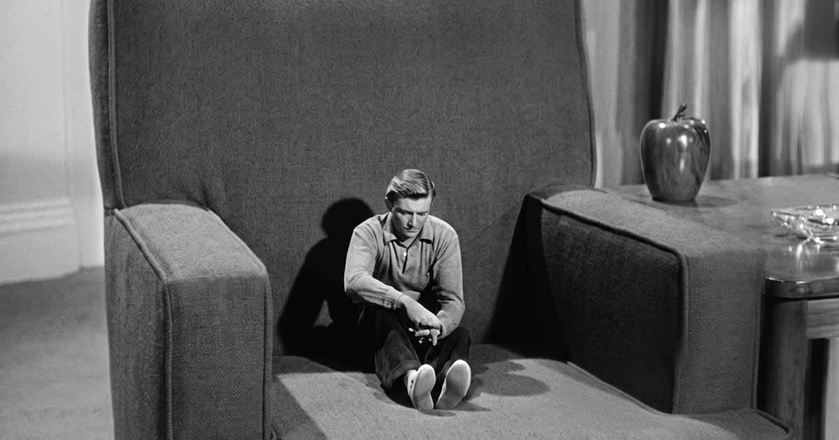 A shrinking Scott Carey sits alone in an oversized armchair in “The Incredible Shrinking Man.”