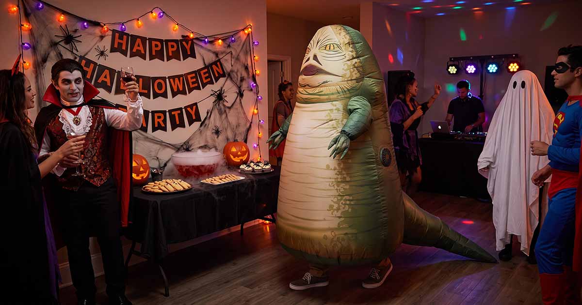 Person wearing an inflatable Jabba the Hutt costume at a Halloween party with other costumed guests.