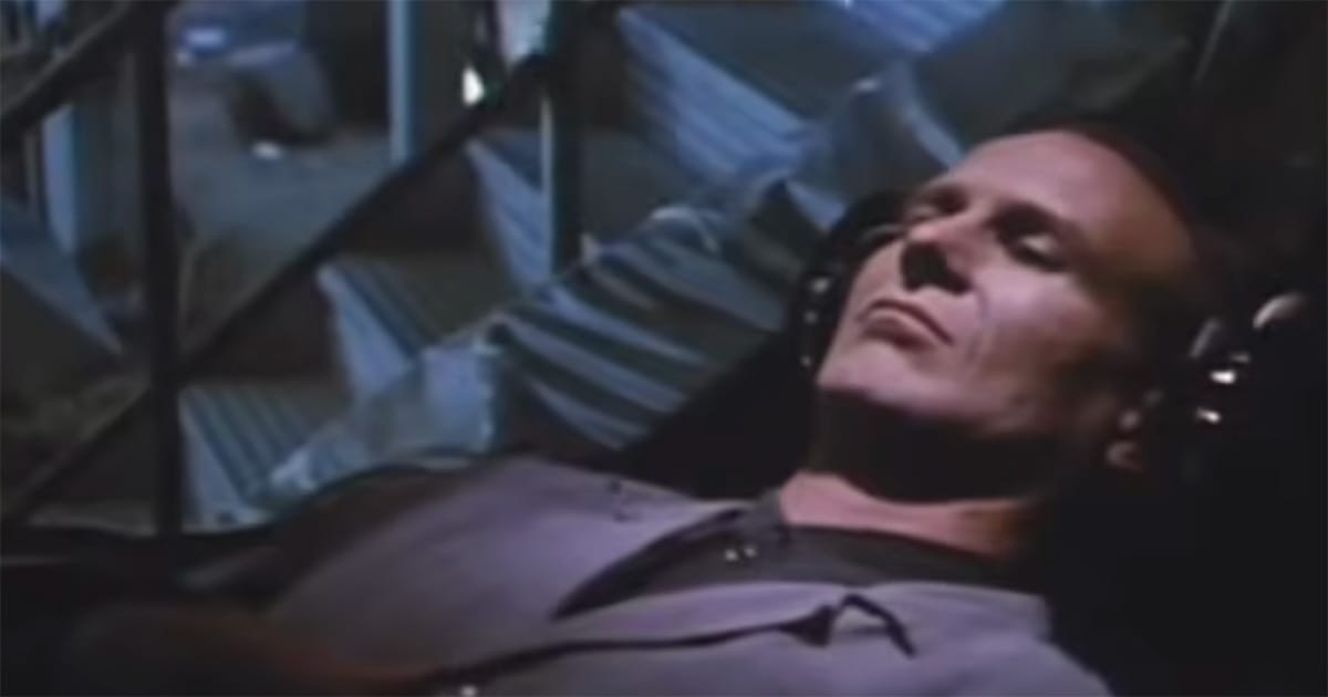 Man lying inside experimental recording equipment during a dream experiment in "Until the End of the World" (1991).