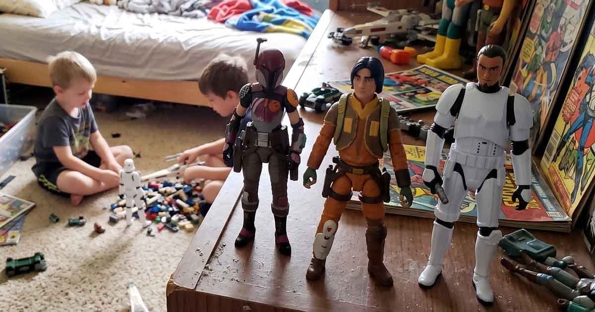 Star Wars Rebels action figures displayed on a bedroom dresser while two children play with toys on the floor behind them.