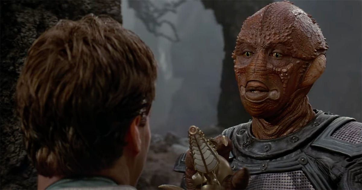 Jeriba Shigan pointing a weapon at Davidge during their first confrontation on Fyrine IV in Enemy Mine (1985) capturing the tension and mistrust that define their initial encounter.