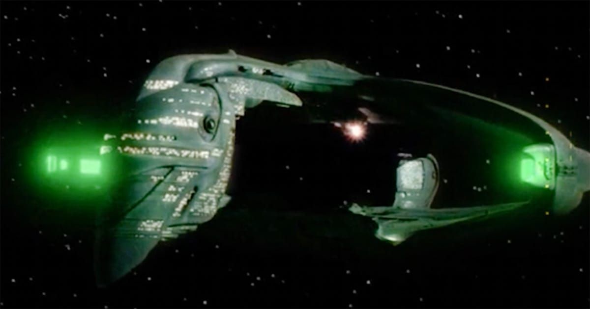 Romulan Warbird starship with green glowing nacelles and clamshell hull in deep space.