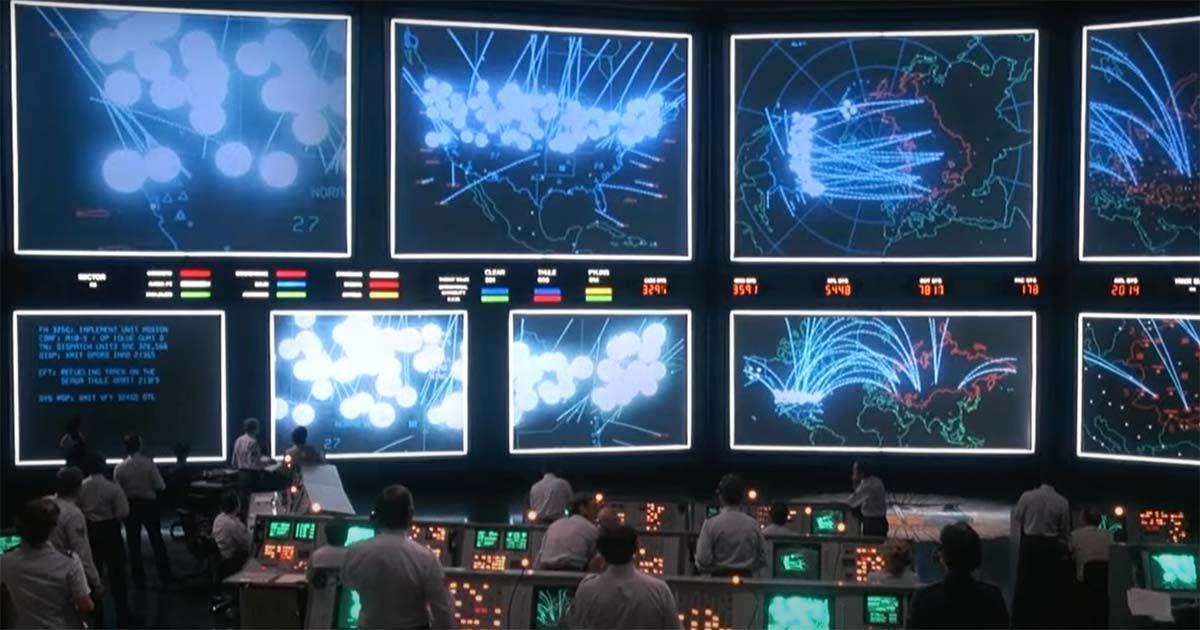 A scene from "WarGames" showing NORAD-style command center screens with missile trajectories lighting up across the globe.