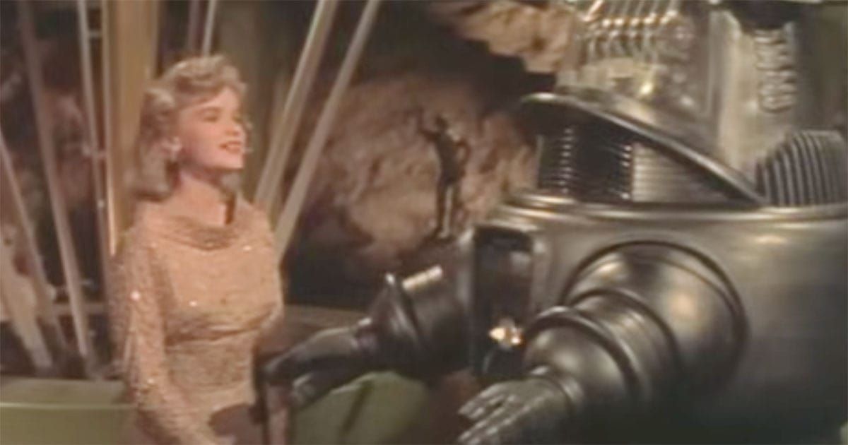 Altaira Morbius speaking with Robby the Robot in the 1956 science fiction classic "Forbidden Planet," exploring themes of technology, ambition, and human nature.