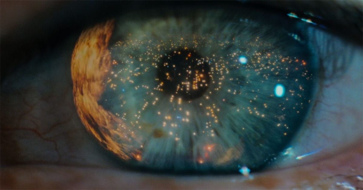 Close-up of an eye reflecting city lights.
