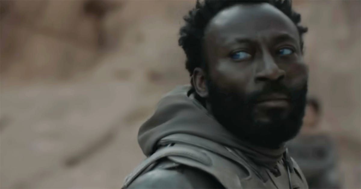 Close-up of Jamis in desert light from Dune 2021, blue-within-blue eyes visible as he turns toward the coming ritual duel.