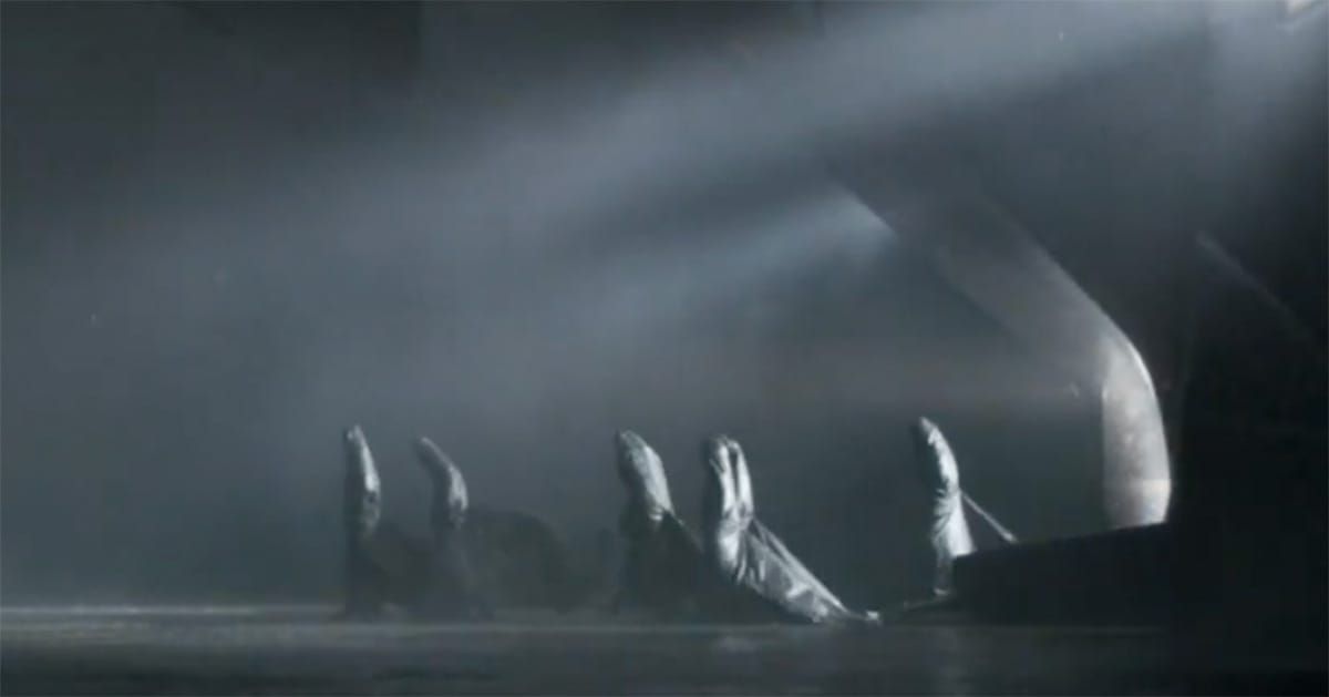 Several cloaked Bene Gesserit sisters process across a dark, misty chamber beneath angled white light.