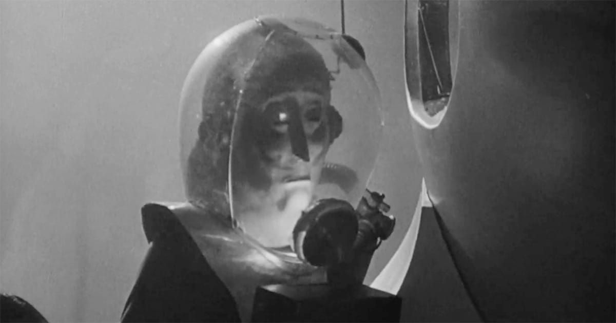 Still alien figure in glass helmet observing humans in 1951 film "The Man from Planet X."