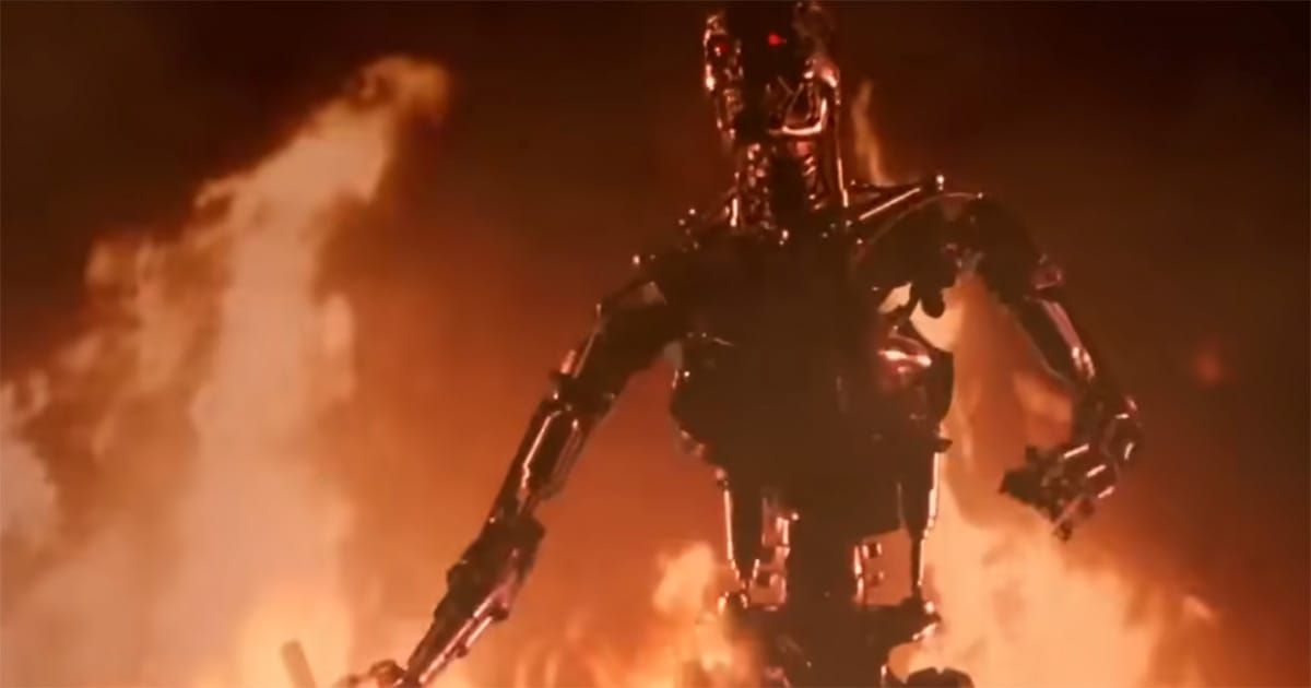 The chrome endoskeleton from "The Terminator" emerges through flames with glowing red eyes.