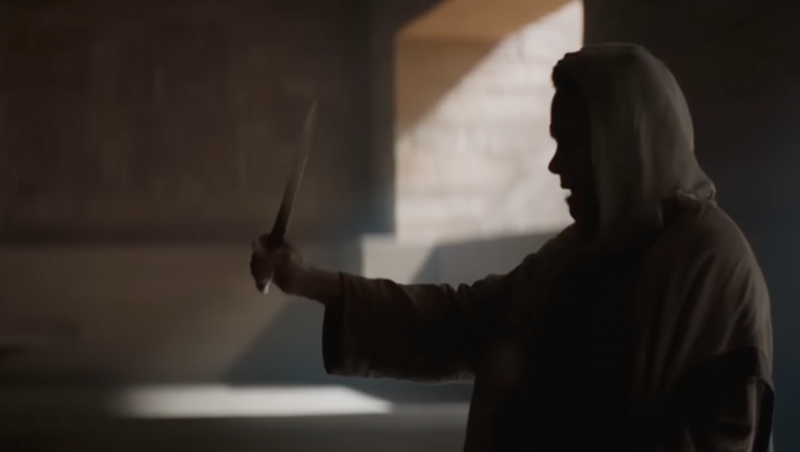 Lady Jessica holding a crysknife in shadowed light on Arrakis in "Dune."