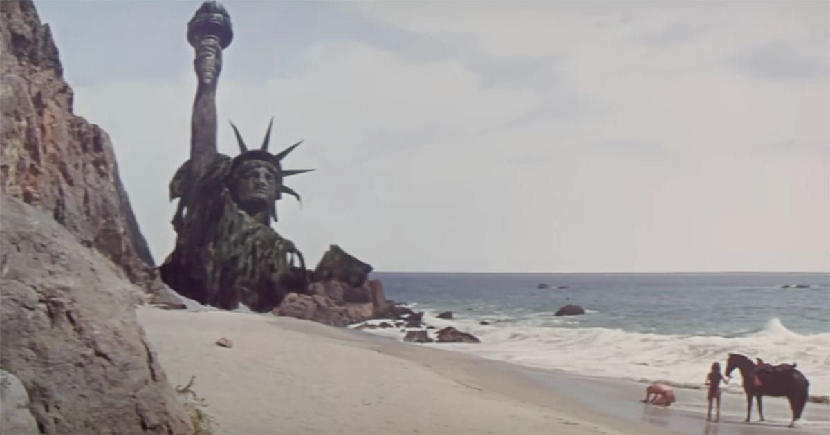 Ruined Statue of Liberty on a deserted beach from "Planet of the Apes," symbolizing the collapse of civilization and the passage of time.