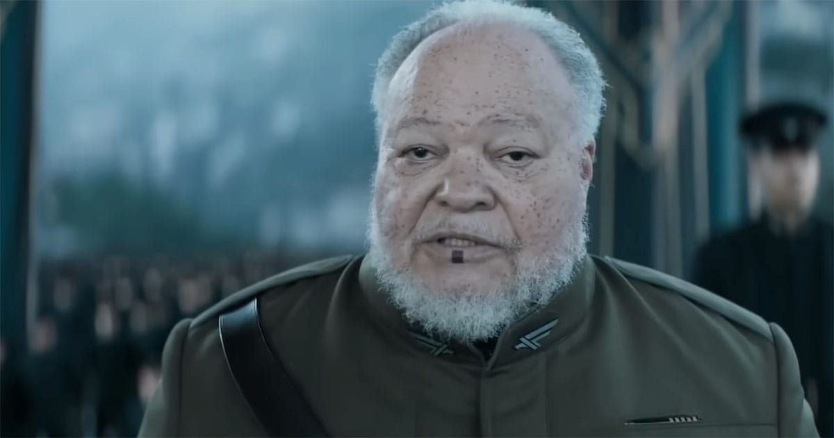 Thufir Hawat from "Dune" wearing an Atreides uniform with the characteristic Mentat lip mark visible.