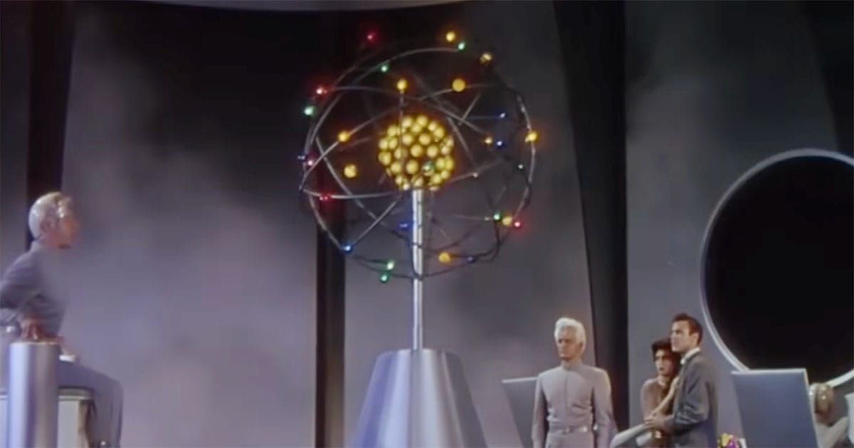 Cal Meacham, Ruth Adams, and Exeter stand beneath a glowing atomic model inside a futuristic Metalunan laboratory in This Island Earth (1955).
