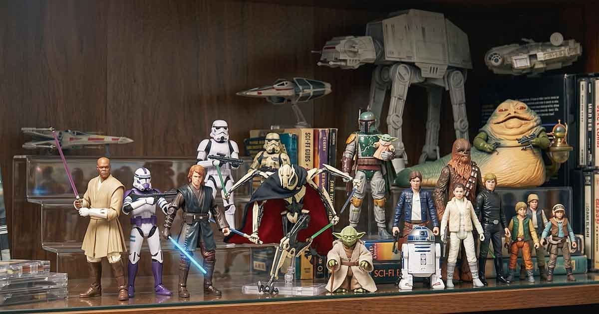 Star Wars figures and vehicles arranged together on a collector’s display shelf.