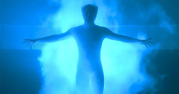 A silhouette of a man surrounded by bright blue light.