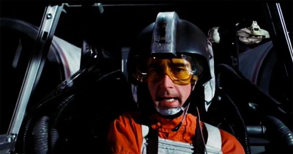 Denis Lawson in full X-wing pilot gear as Wedge Antilles, seated in the cockpit during a "Star Wars" battle scene