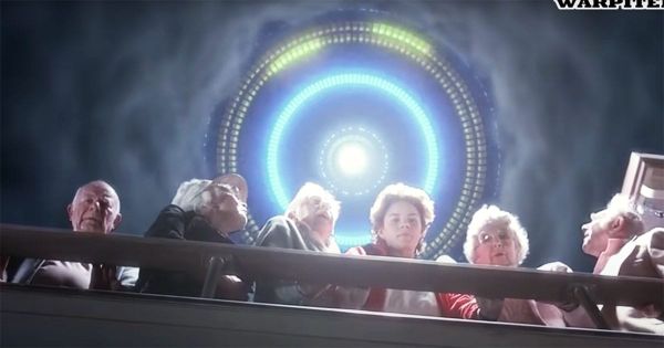 Elderly characters looking up at a radiant alien spacecraft in the sky.
