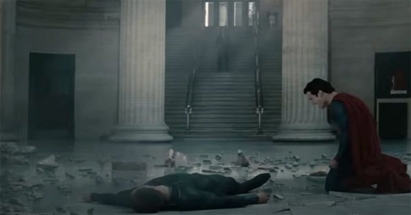 Superman kneels beside General Zod’s body in a ruined building, mourning the cost of his moral decision in "Man of Steel"