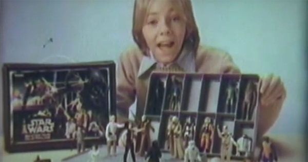 1980s boy displaying Kenner "Star Wars" action figures in vintage toy case with original packaging visible.